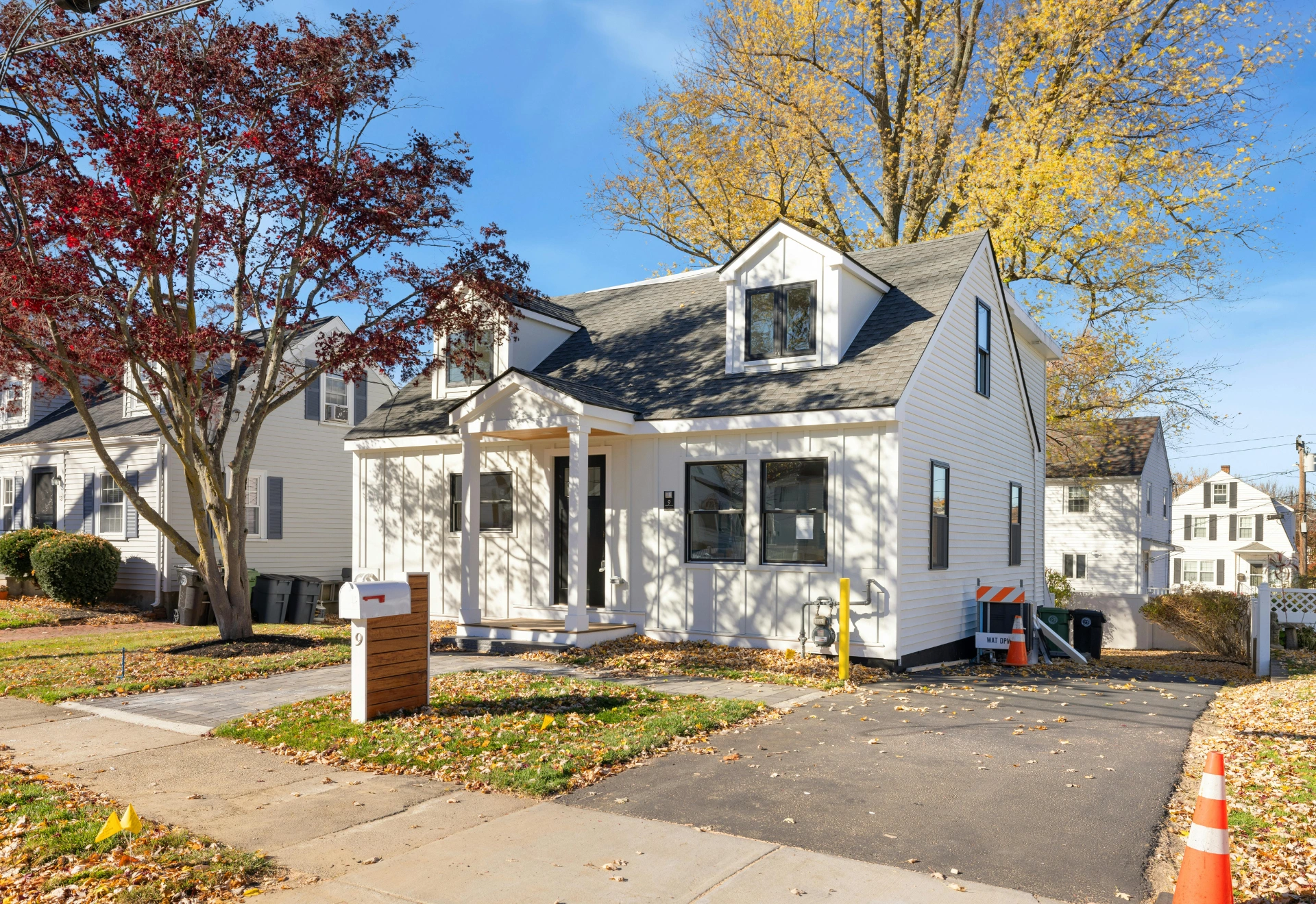 White cottage with red-leaf tree