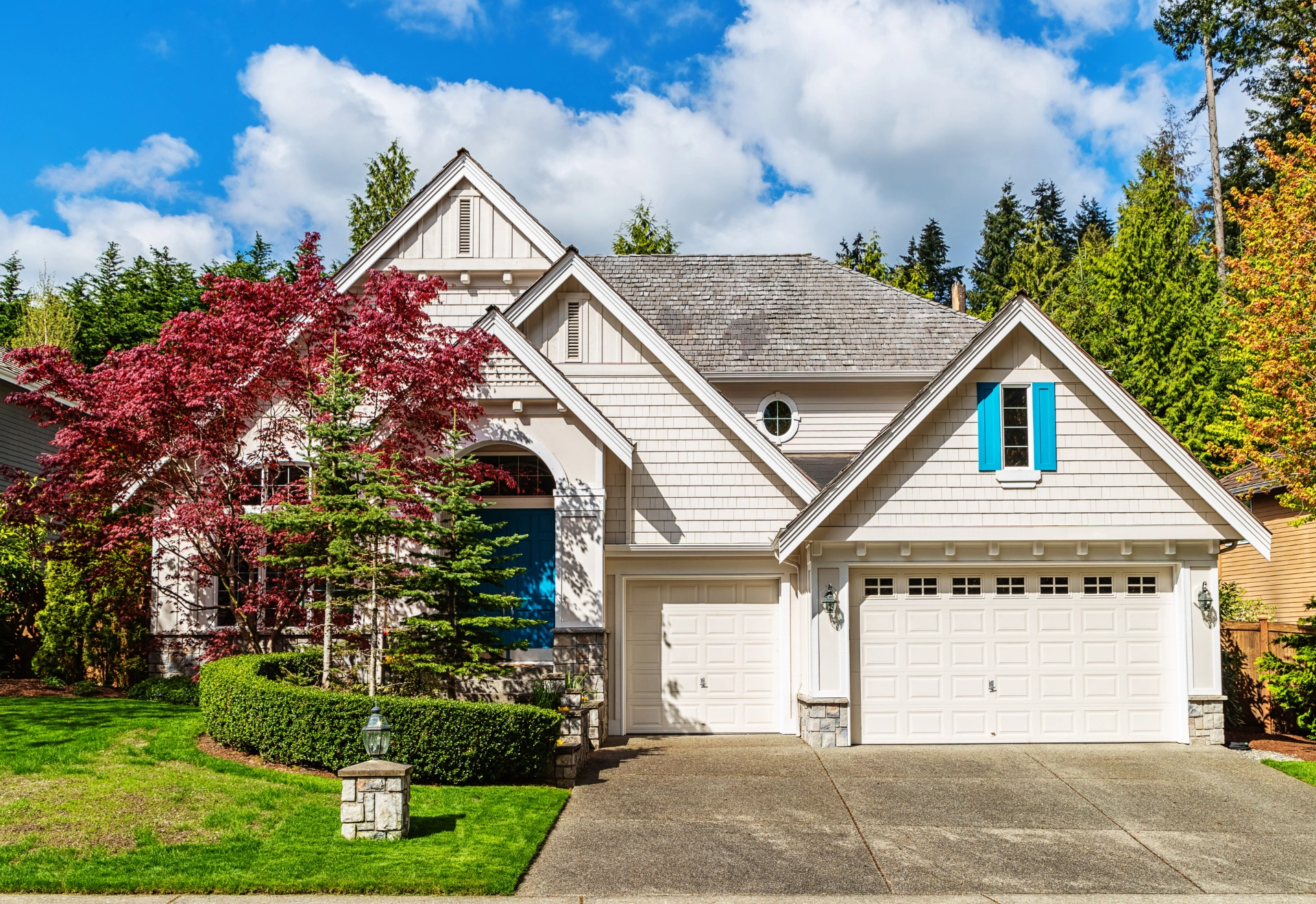 Beige two-story home with teal shutters