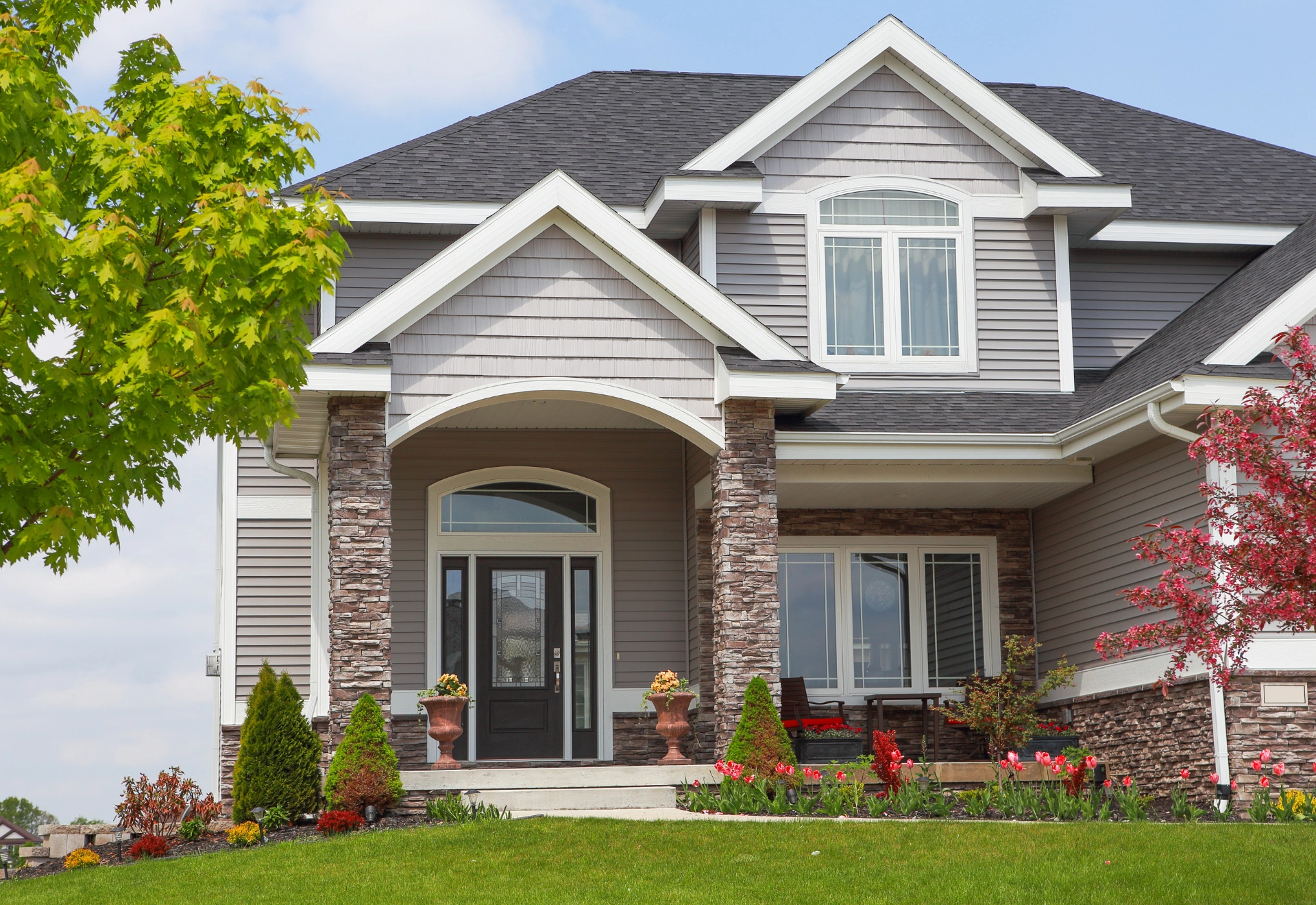 Gray two-story home with stone entryway