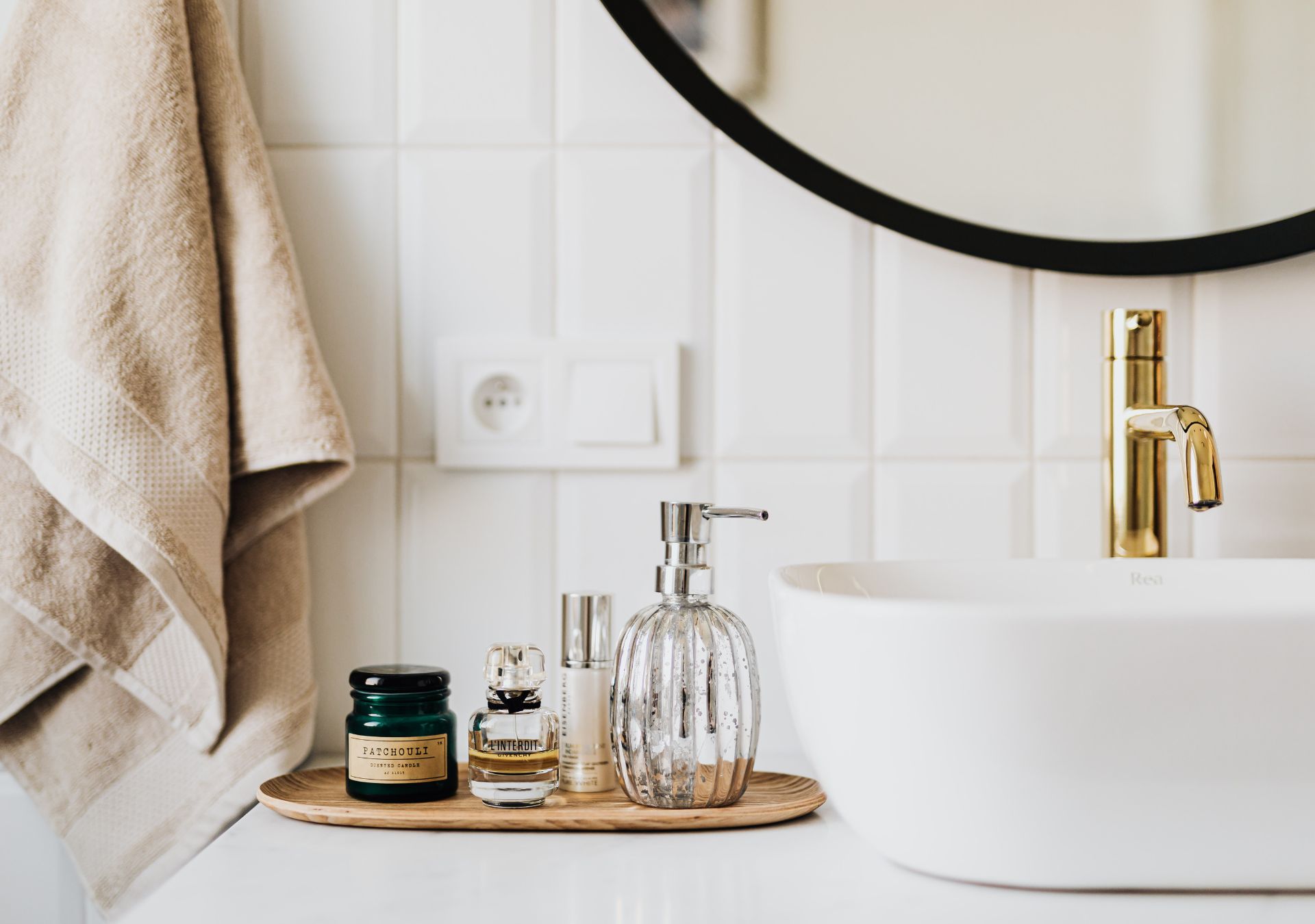 Bathroom sink with gold faucet and round mirror