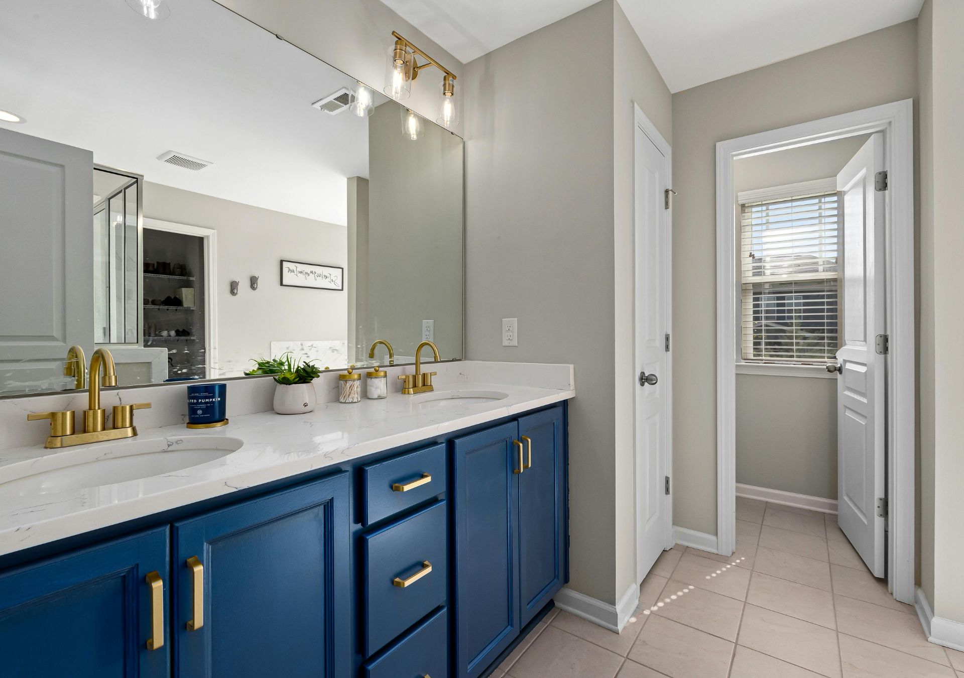 Bathroom with blue vanity and gold fixtures